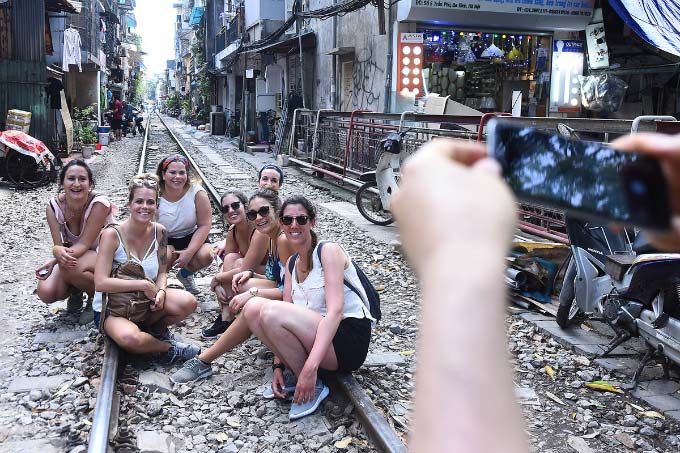 In central Hanoi, foreign tourists turn train track into outdoor studio