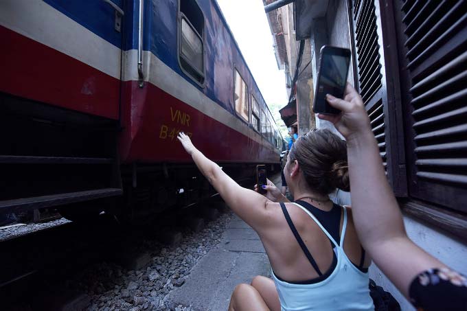 In central Hanoi, foreign tourists turn train track into outdoor studio