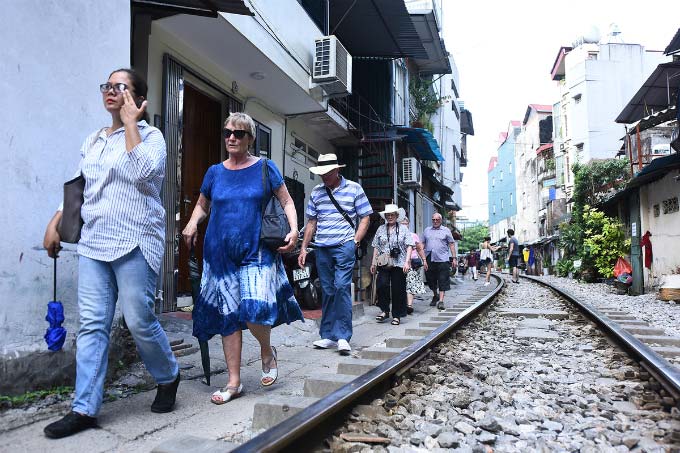 In central Hanoi, foreign tourists turn train track into outdoor studio